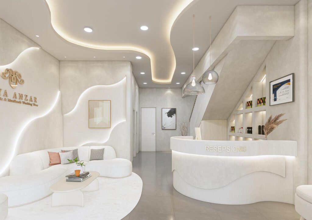 Area resepsionis klinik kecantikan Naya Anzar dengan meja lengkung, sofa tunggu, backdrop logo, indirect lighting, dan interior modern elegan.